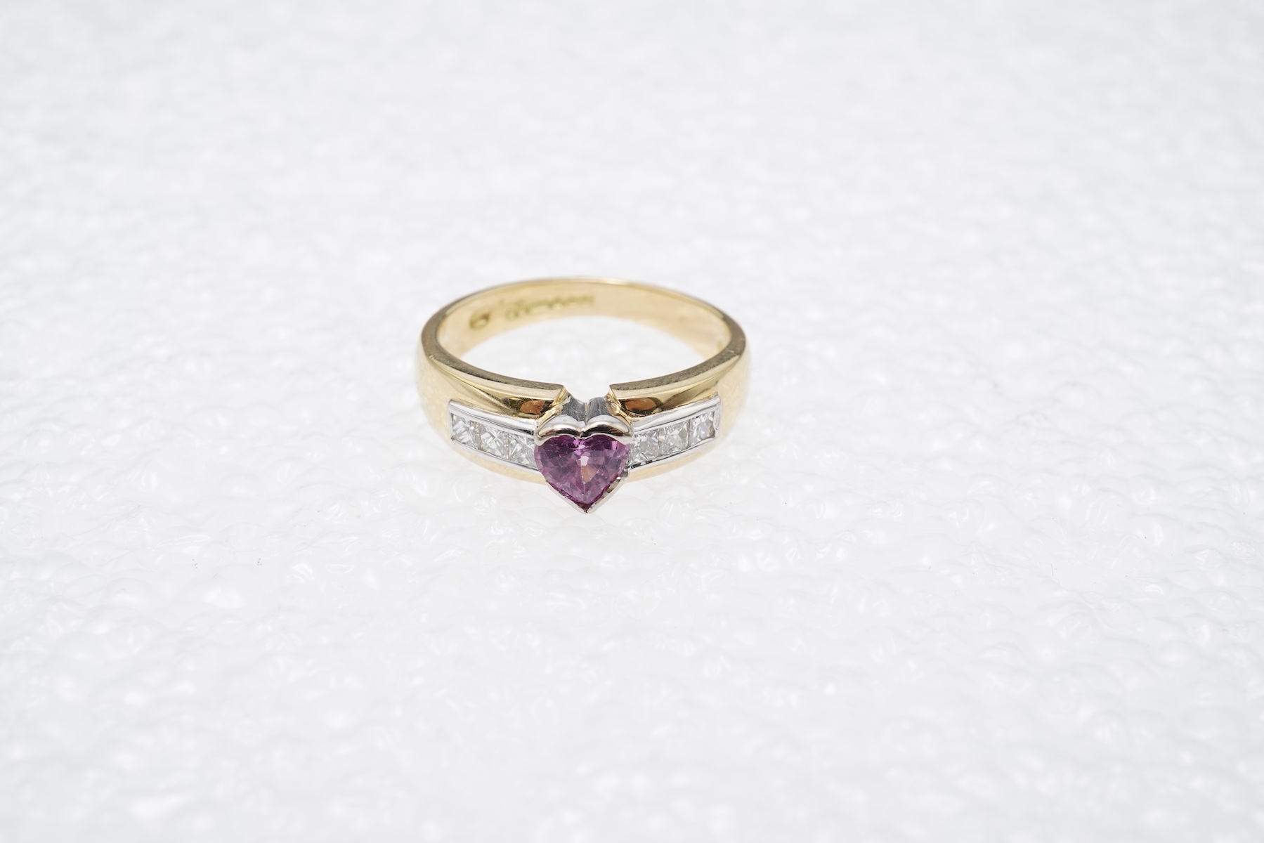 A pink sapphire and diamond ring